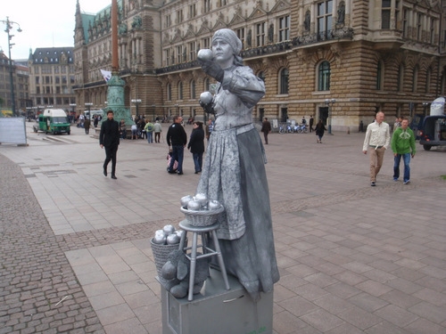 This lady is performing (as a statue) on the plaza.